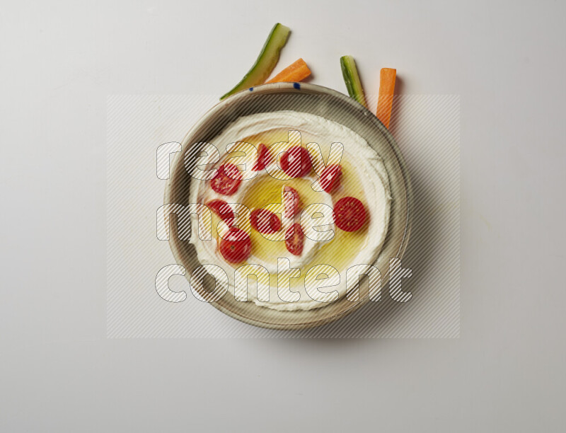 Lebnah garnished with cherry tomato in a grey pottery plate on a white background