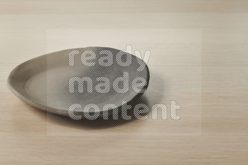 صحن فخاري متعدد الألوان على خلفية خشبية فاتحة