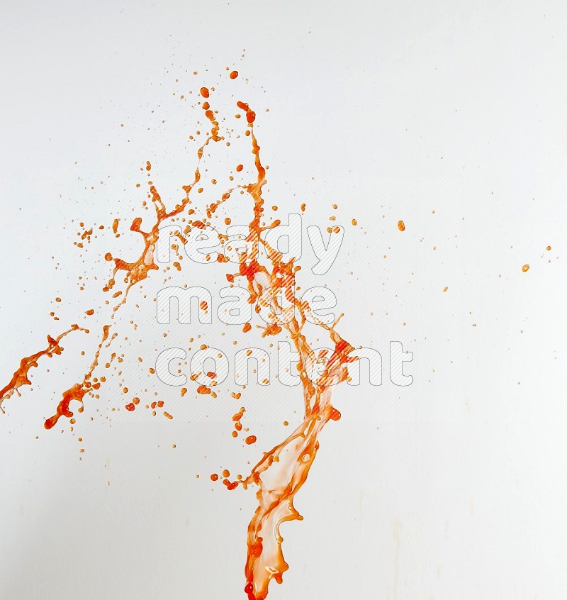 Orange liquid splash and drops on white background