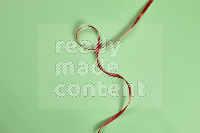 مجموعة من أدوات الخياطة والتفصيل حمراء اللون على خلفية خضراء