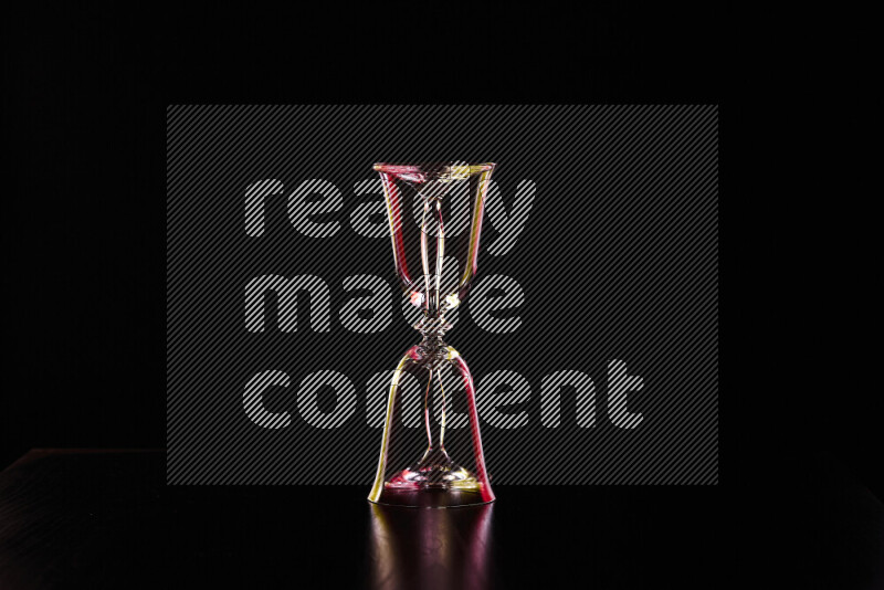 Glassware with rim light in red and yellow against black background