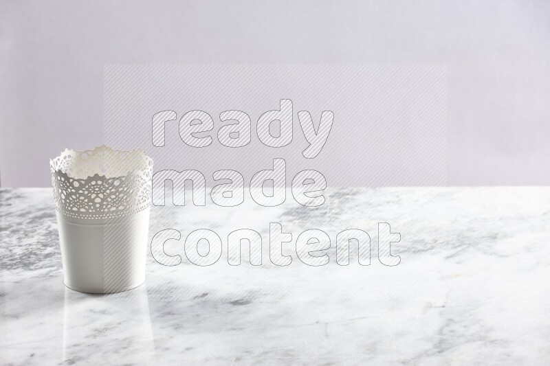 An empty white plant pot on grey marble background