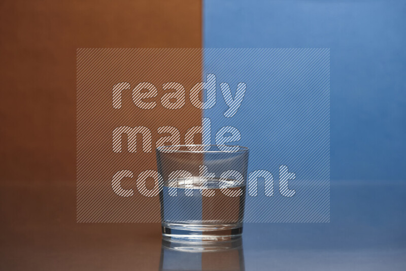 The image features a clear glassware filled with water, set against brown and blue background