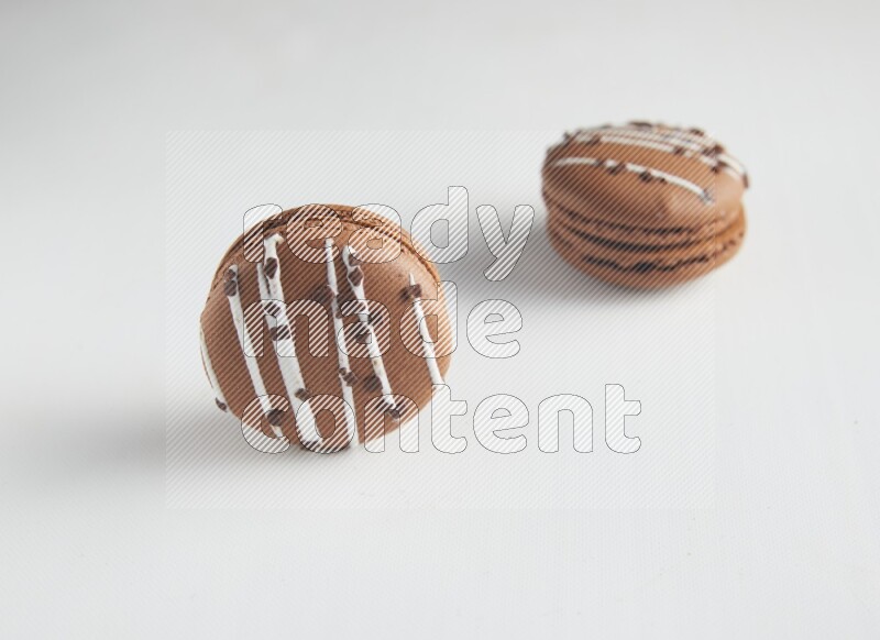 45º Shot of two Brown white Chocolate Caramel macarons on white background