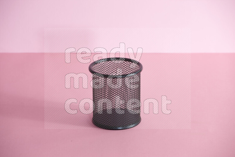 أقلام ومستلزمات مدرسية مختلفة أخري في حامل أقلام معدني على خلفية وردية