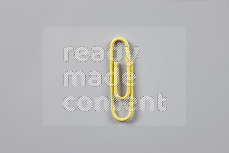 Yellow paper clips isolated on a grey background