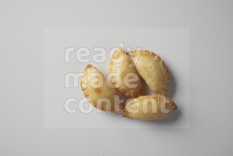 Four fried sambosa from a top angle on a white background