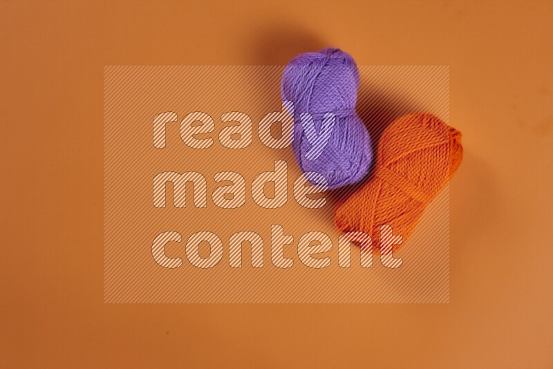 A purple collection of sewing and tailoring tools arranged on a orange background