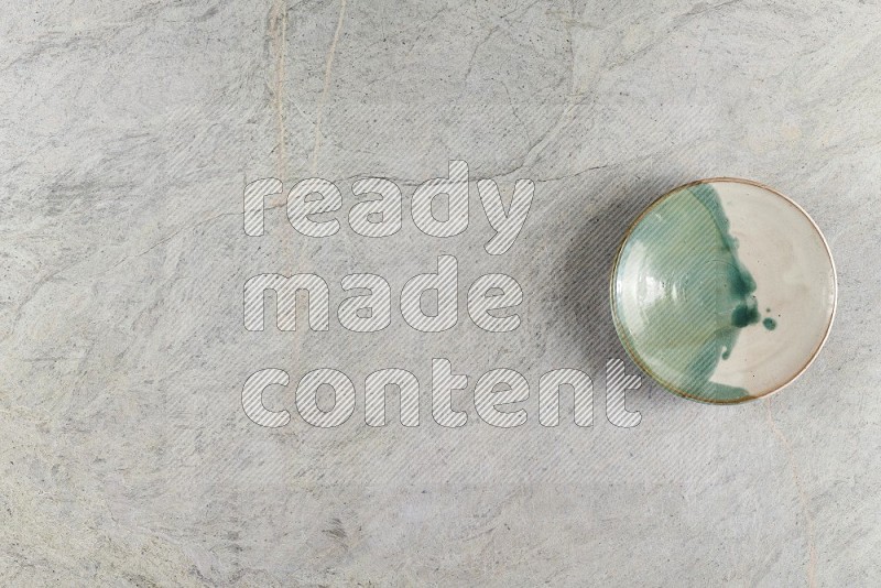 Top View Shot Of A Multicolored Pottery Bowl On Grey Marble Flooring