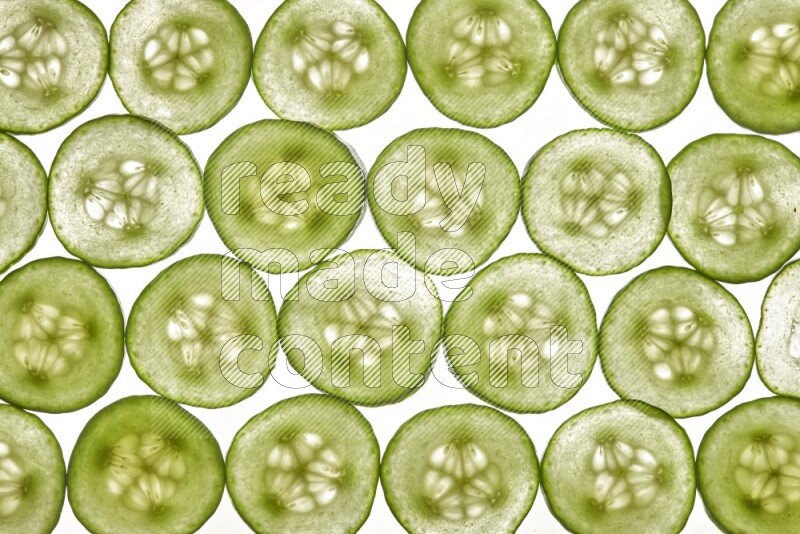 Cucumber slices on illuminated white background