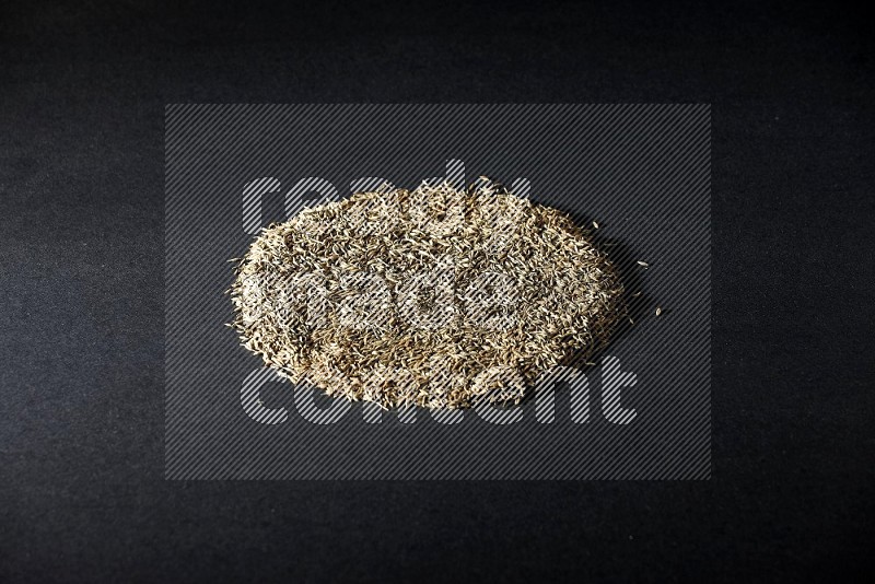 Cumin seeds on black flooring