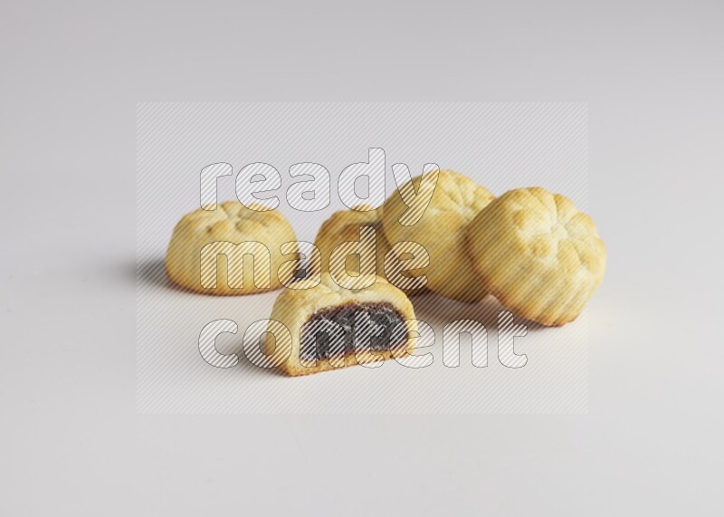 Five Pieces of Maamoul filled with date one of them is cut direct on white background