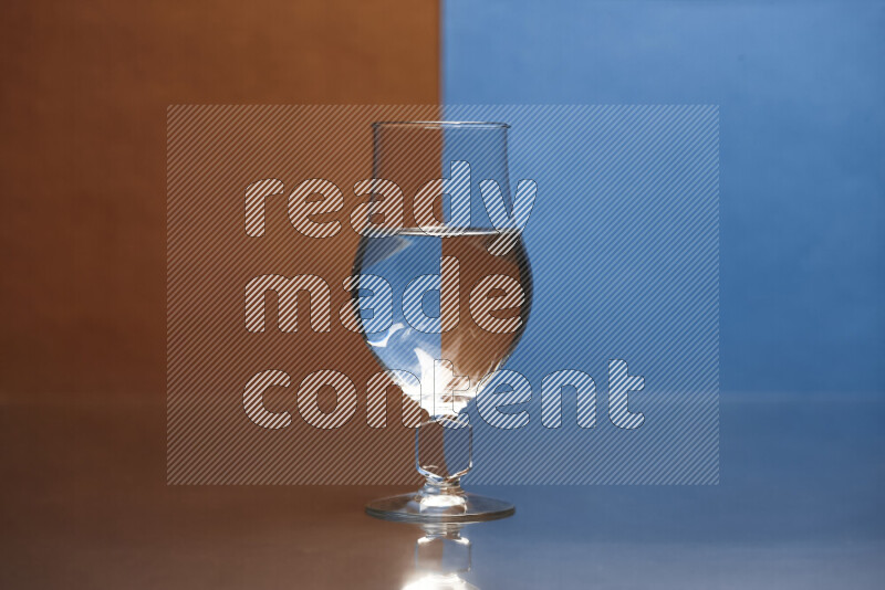 The image features a clear glassware filled with water, set against brown and blue background