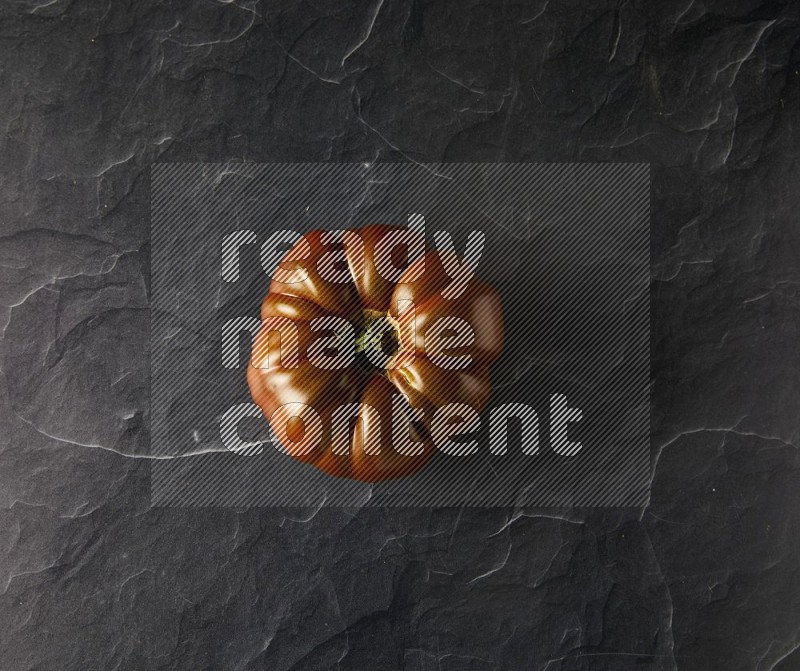 Single Topview Heirloom tomato on a black slate background