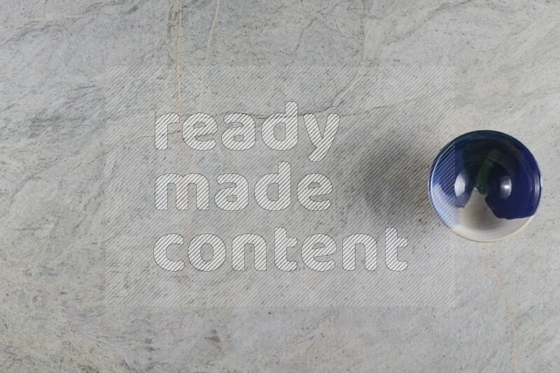 وعاء فخاري متعدد الألوان على خلفية من الرخام الرمادي