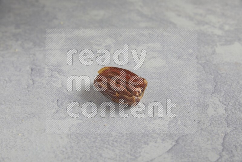 pecan stuffed date on alight grey background