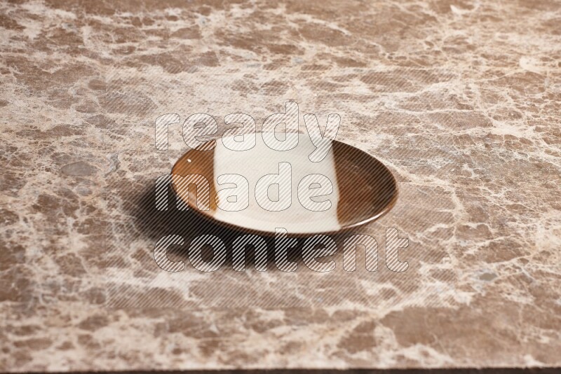 A multicolored pottery plate on beige marble background