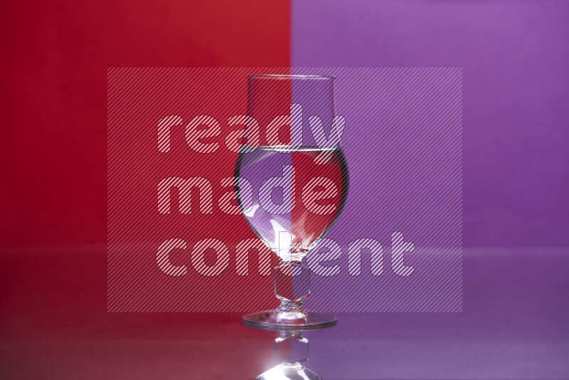 The image features a clear glassware filled with water, set against red and purple background