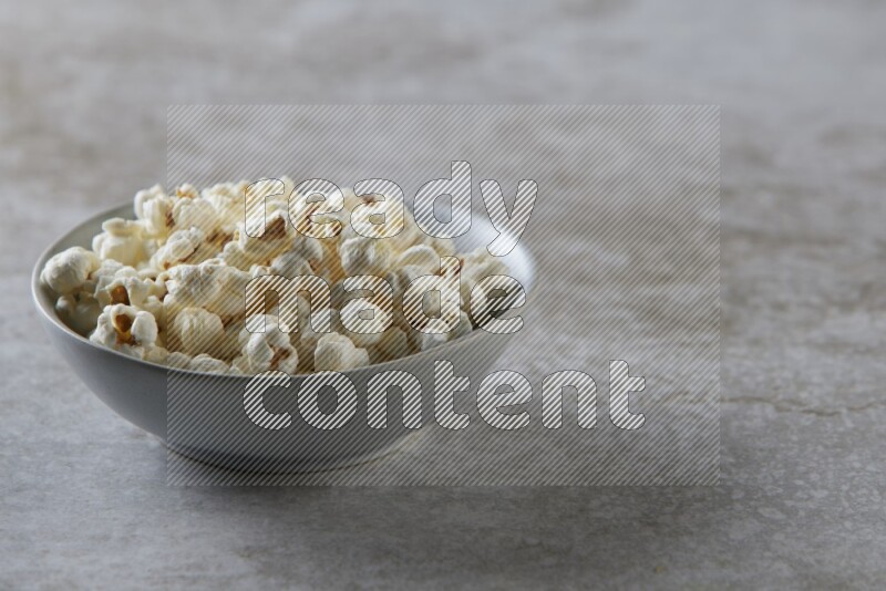 popcorn in gray bowl on a grey textured countertop