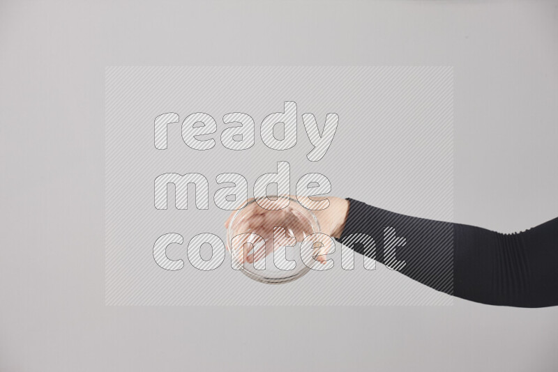A woman in black abaya holding different glassware in different positions