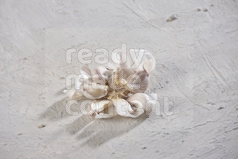 رأس ثوم مشقوقة تظهر الفصوص بداخلها على خلفية بيضاء