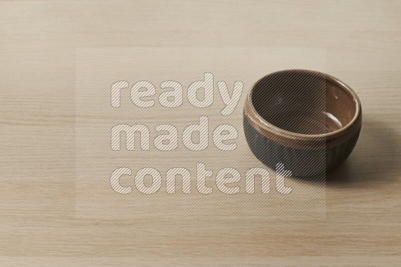 A multicolored pottery bowl on light wooden background