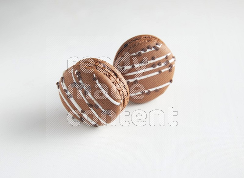 45º Shot of two Brown white Chocolate Caramel macarons on white background