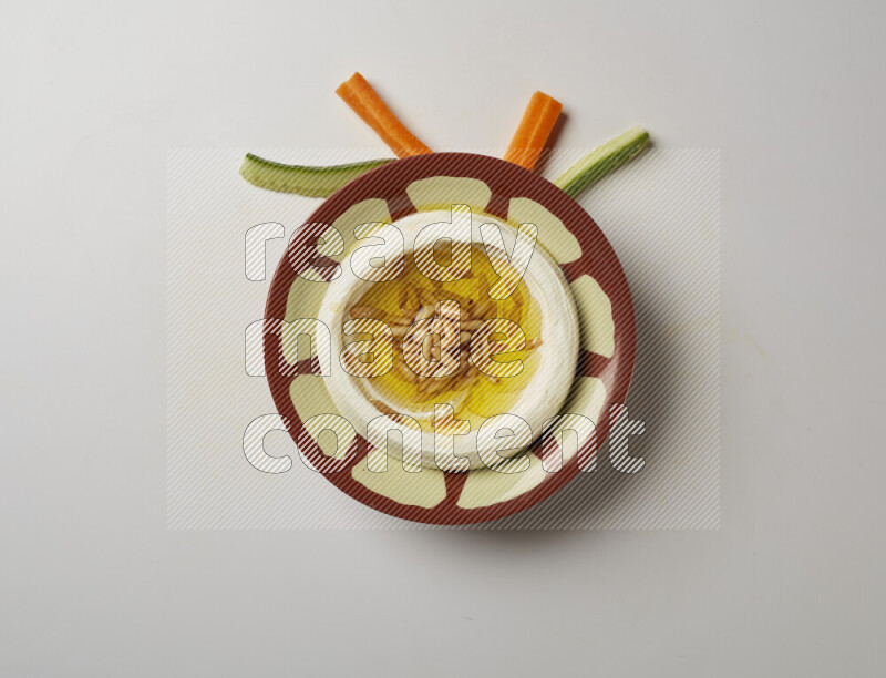 Lebnah garnished with pine nuts in a traditional plate on a white background