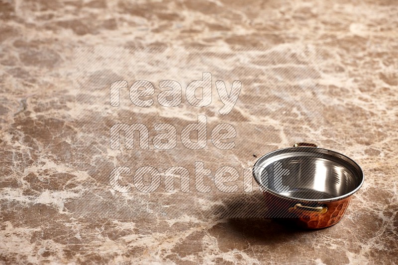 Small Copper Pot on Beige Marble Flooring, 45 degrees