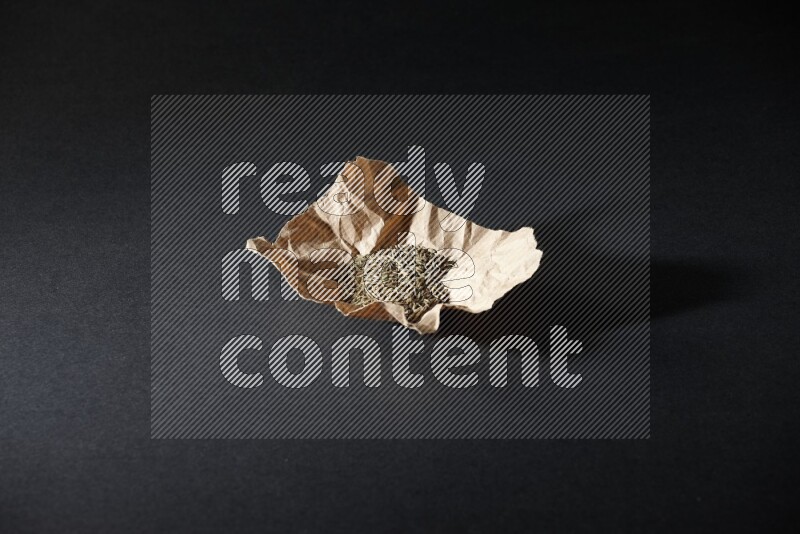 حبوب الكمون في قطعة من الورق على خلفية سوداء