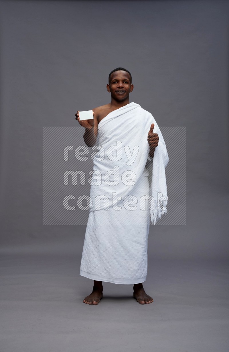 A man wearing Ehram Standing holding ATM card on gray background