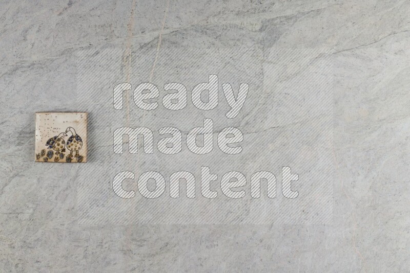 A decorative pottery coaster on grey marble background