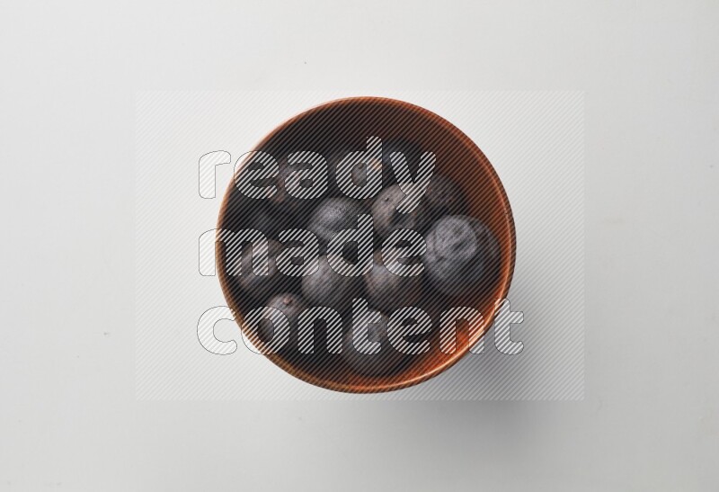 Top-view shot of dried lime (loomi) in a container on white background