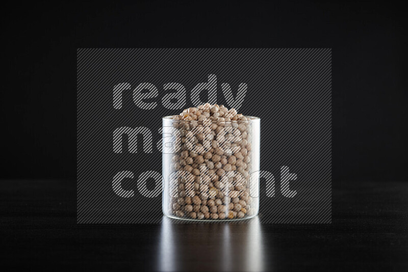 Chickpeas in a glass jar on black background