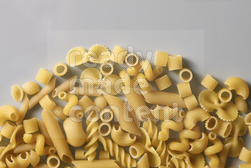 Different pasta types on light blue background
