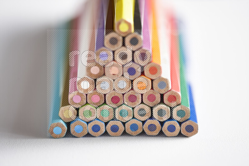 A close-up of the tips of colored pencils arranged in a bundle on white background