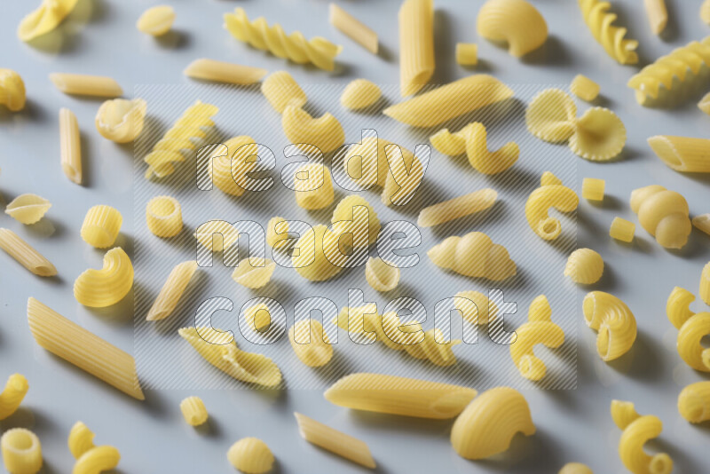 Different pasta types on light blue background