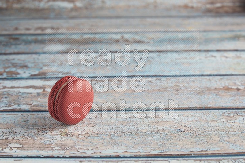 45º Shot of Red Velvet macaron on light blue wooden background