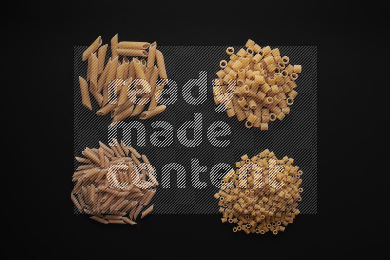 Different pasta types in bunches on black background