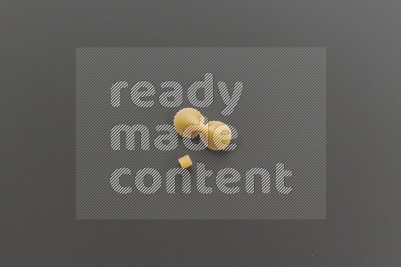 Small rings pasta with other types of pasta on grey background