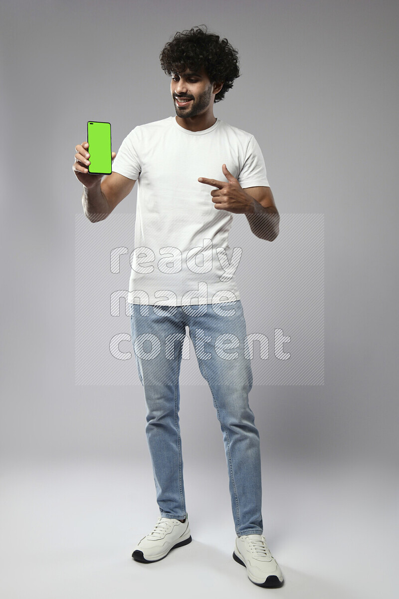 A man wearing casual standing and showing a phone screen on white background