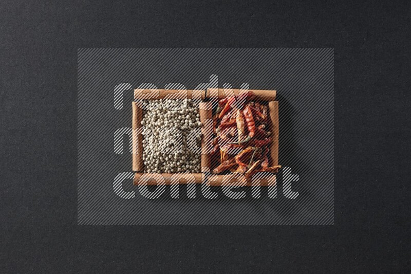 2 squares of cinnamon sticks full of chilis and white peppers on black flooring