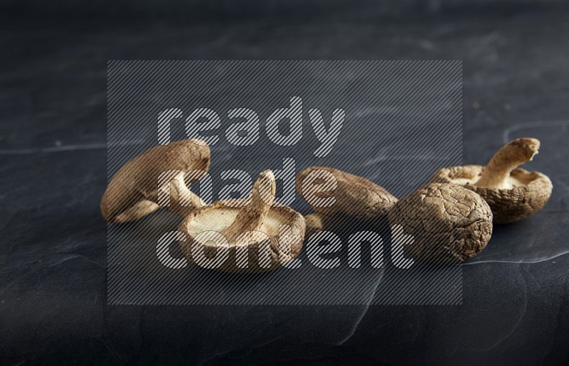 45 degre shiitake mushrooms on a textured black slate background