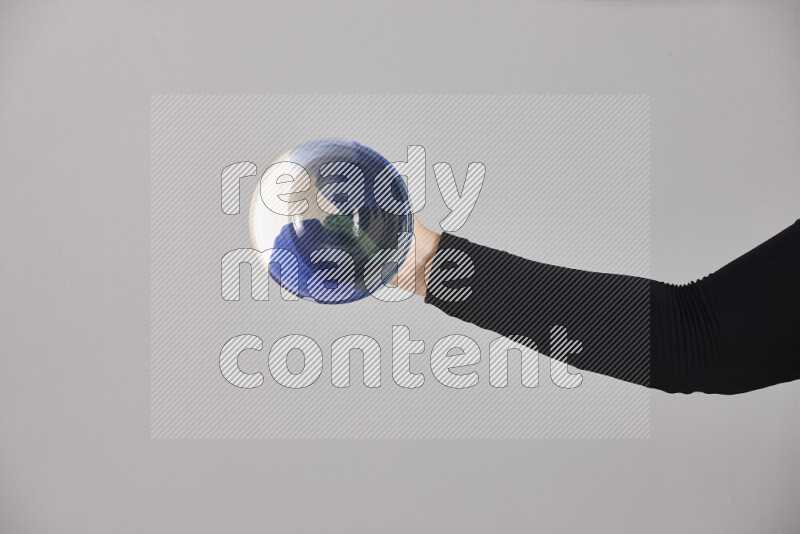 امرأة ترتدي عباءة سوداء تحمل أدوات فخارية مختلفة في أوضاع متعددة