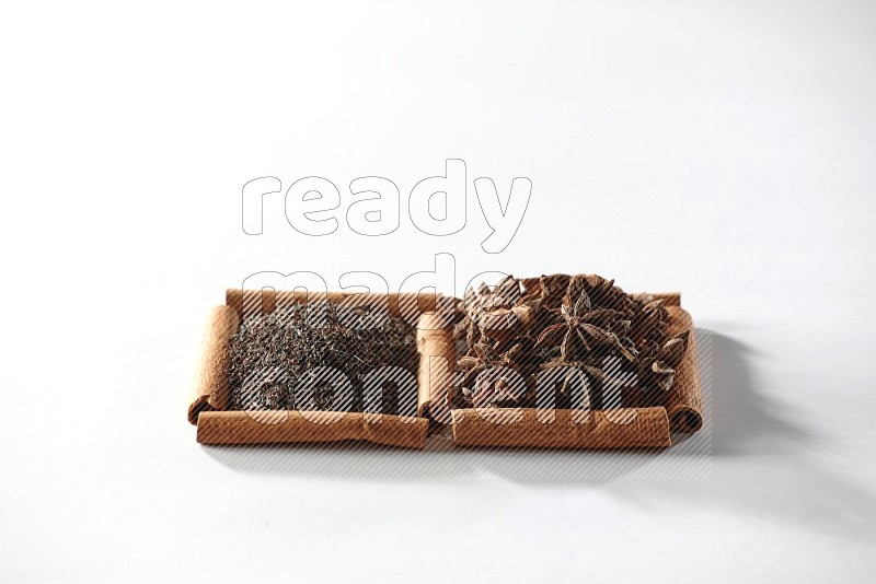 2 squares of cinnamon sticks full of star anise and black tea on white flooring