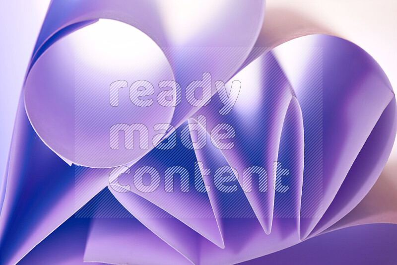 An artistic display of paper folds creating a harmonious blend of geometric shapes, highlighted by soft lighting in purple tones