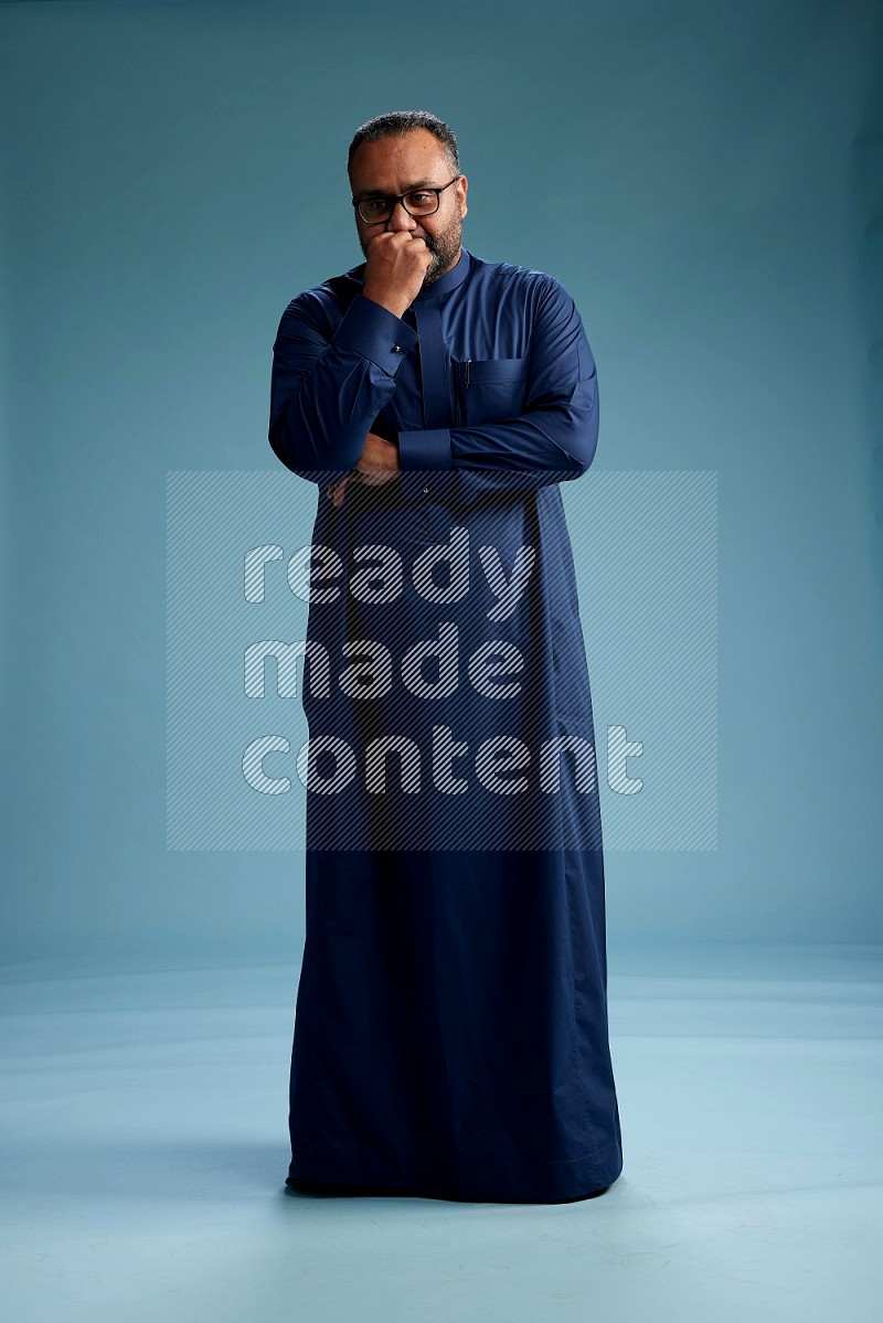 Saudi Man without shimag Standing Interacting with the camera on blue background