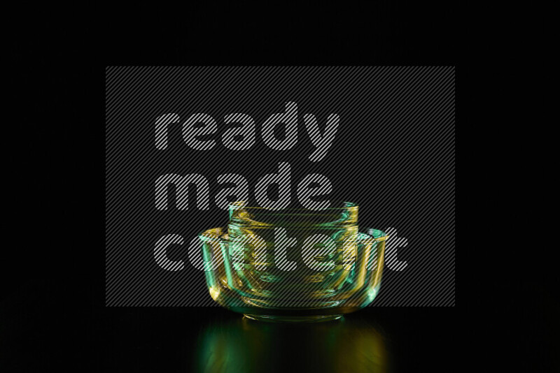 Glassware with rim light in green and yellow against black background