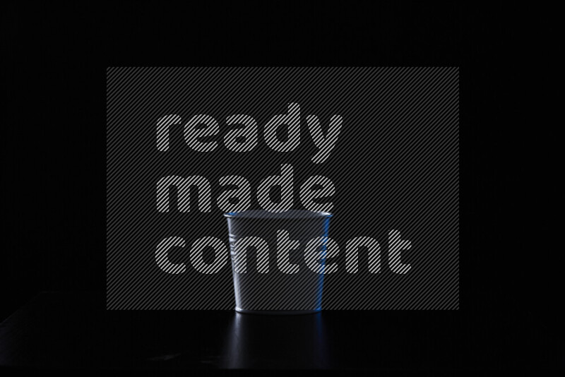 A plant pot with colored rim light against black background