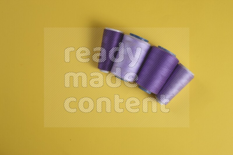 A purple collection of sewing and tailoring tools arranged on a yellow background